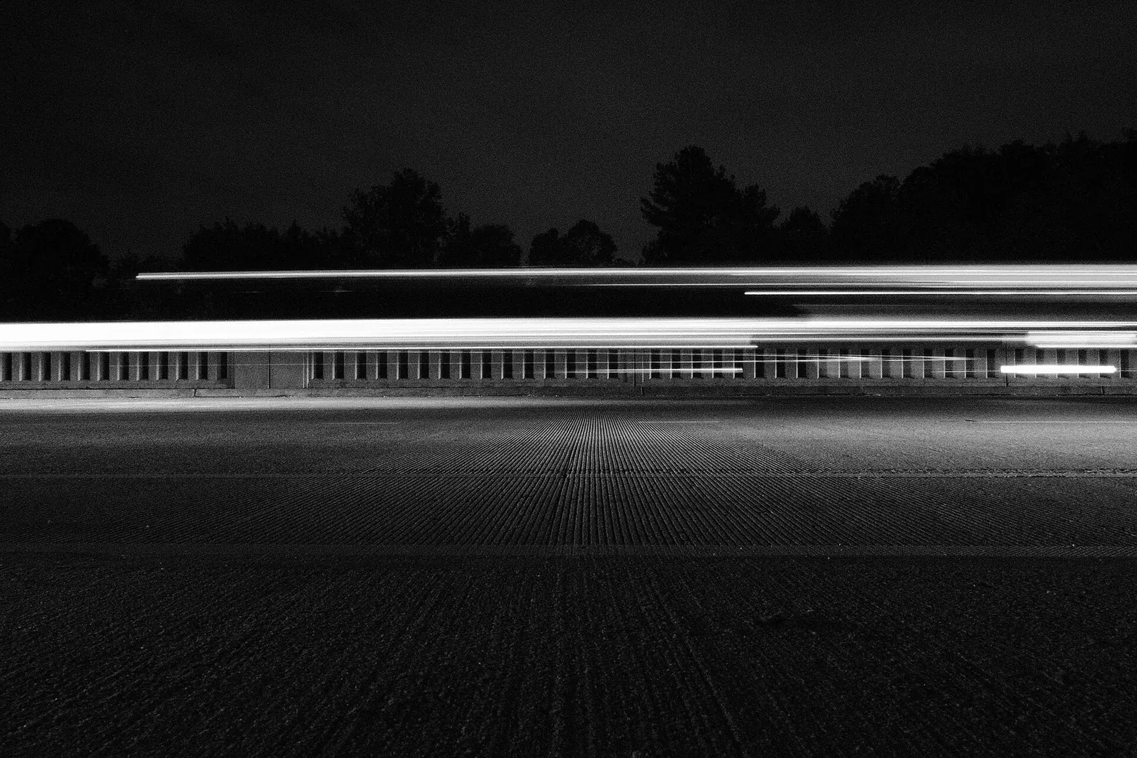 Vehicle light trails streaking along a road at night