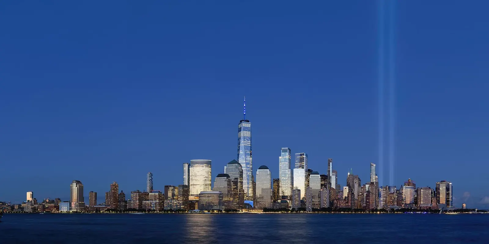 The Manhattan skyline lit at night viewed from across the water in New Jersey