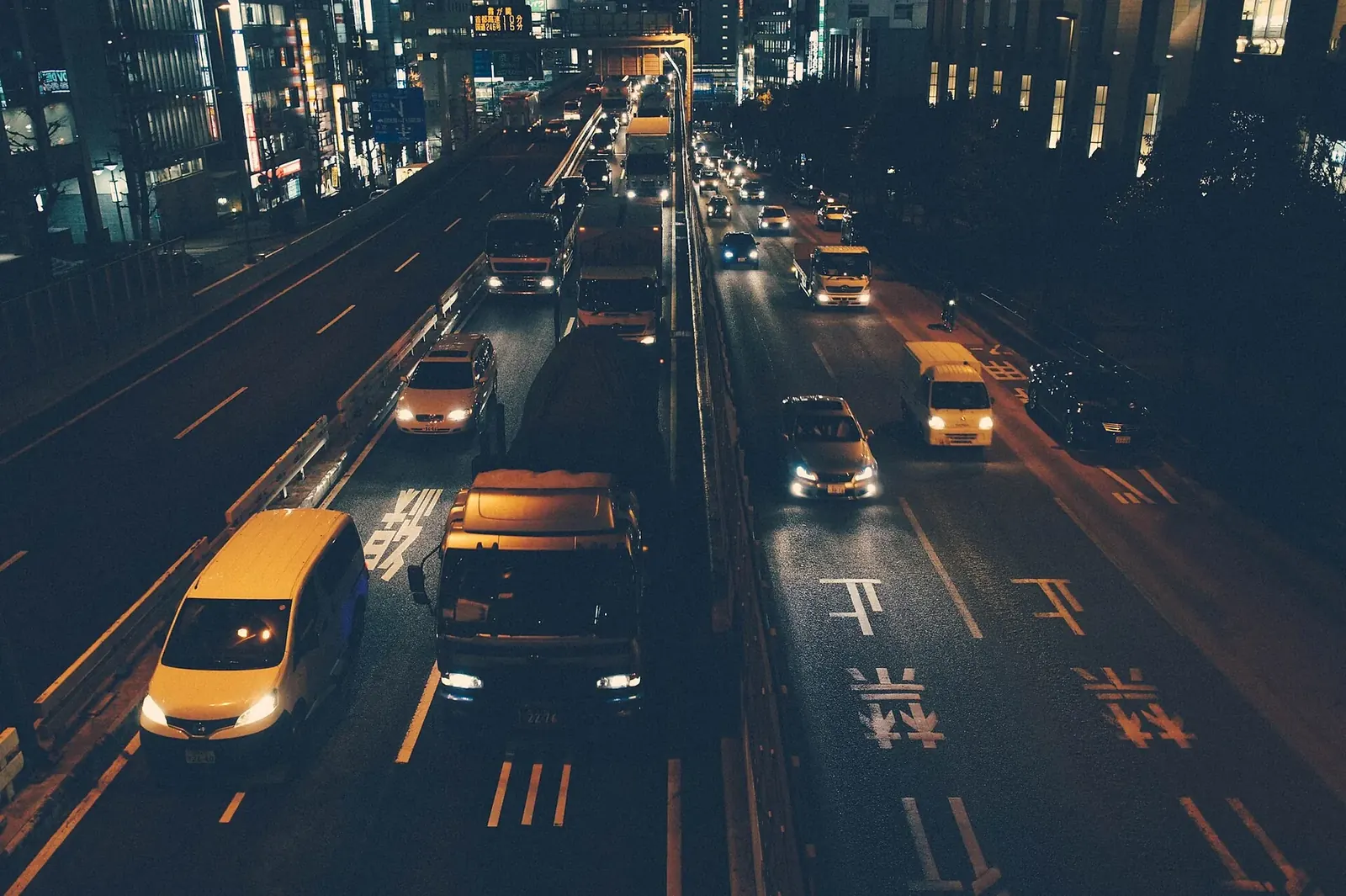 Night traffic streaming along a city avenue seen from above
